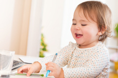 stock-photo-75613615-happy-toddler-girl-with-a-huge-smile-playing